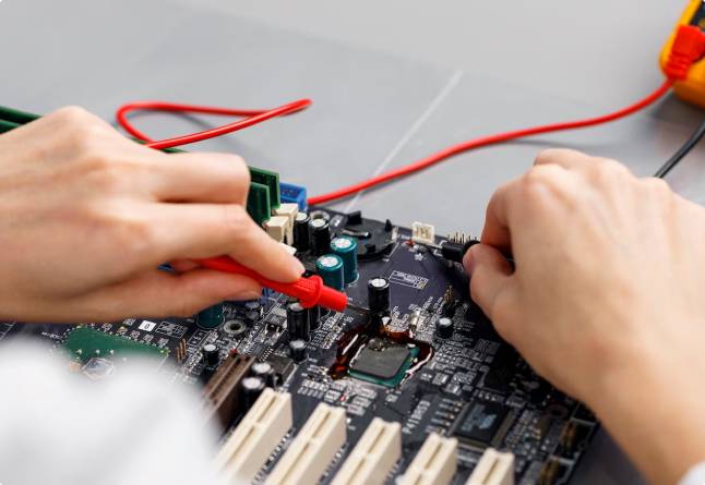Hands testing a circuit board with probes.