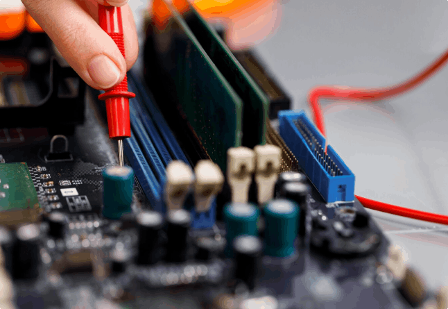 Hand using multimeter on computer motherboard.